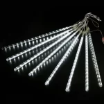 Meteor Shower LED svetleće zvezde – 8 cevi dekorativnih lampica bele boje poredjane jedna do druge u tamnom prostoru